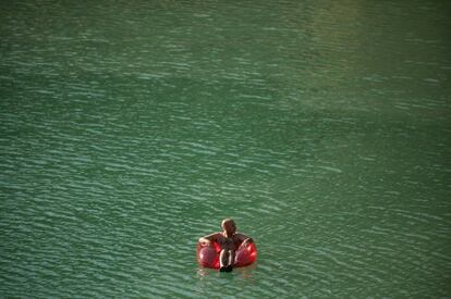 Un hombre se relaja en una silla hinchable en el embalse Conde de Guadalhorce, en Ardales (Málaga).