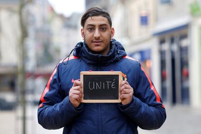 Mehdi Belhabassi, 21, a shop assistant, holds a blackboard with the word "unite" (unity), the most important election issue for him, as he poses for Reuters in Chartres, France February 1, 2017. He said: "It's important for us to live together in peace and respect each other. No matter where we come from, we're all French and we're all equal." REUTERS/Stephane Mahe SEARCH "ELECTION CHARTRES" FOR THIS STORY. SEARCH "THE WIDER IMAGE" FOR ALL STORIES