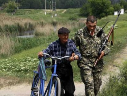 Um rebelde pró-russo ajuda um homem em Slaviansk.