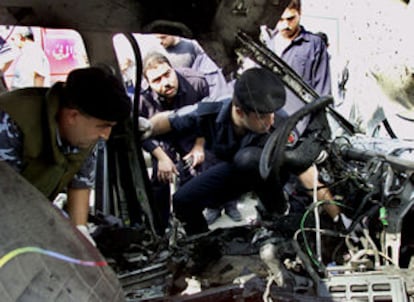 Policías palestinos inspeccionan el coche del oficial de los servicio secretos tras la explosión.