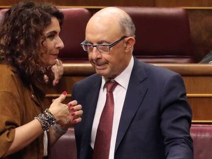 La ministra de Hacienda María Jesús Montero (i) conversa con el diputado popular y exministro Cristóbal Montoro.