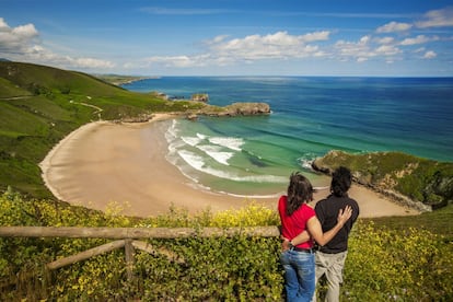 Una pareja se abraza frente a la playa de Torimbia, en el concejo de Llanes.