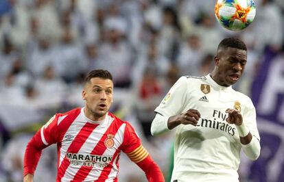 El delantero brasileño del Real Madrid Vinicius Junior cabecea el balón ante el centrocampista del Girona Alex Granell.