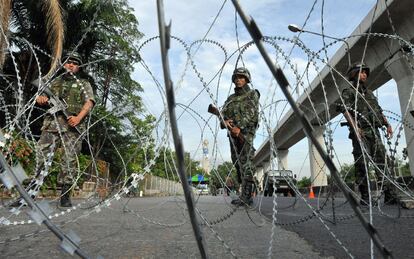 Un grupo de militares tailandeses vigilan el cruce bloqueado de una de las avenidas de la parte baja de Bangkok.