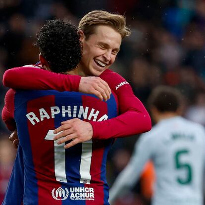 Barcelona's Frenkie de Jong, right, celebrates with Barcelona's Raphinha after scoring his side's third goal during a Spanish La Liga soccer match between Barcelona and Getafe at the Olimpic Lluis Companys stadium in Barcelona, Spain, Saturday, Feb. 24, 2024. (AP Photo/Joan Monfort)