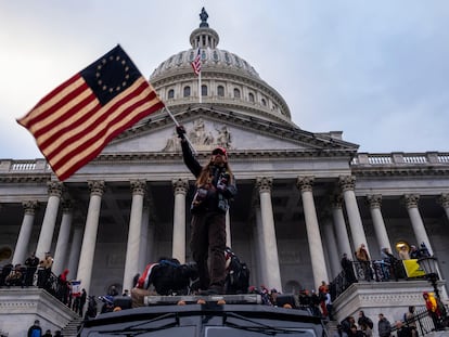 2FKA894 Washington DC, USA. 6th Jan, 2021. A man waves a flag in front of the Capitol Building during the storming of the building by Trump supporters.