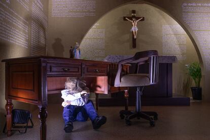 Una sala de la exhibición 'Habitaciones que no callan' recrea una iglesia católica con el maniquí de un niño escondido bajo el púlpito.