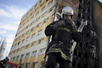 Un bombero, frente al albergue de inmigrantes incendiado en Dijon (Francia).