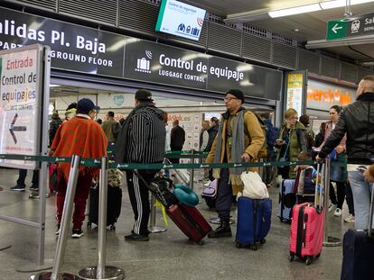 Viajeros con maletas en el control de acceso de la estación Almudena Grandes-Atocha, en Madrid.