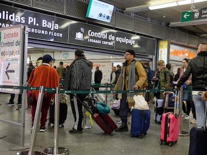 Viajeros con maletas en el control de acceso de la estación Almudena Grandes-Atocha, en Madrid.