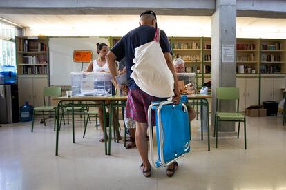 Un hombre va a votar con su silla de playa en el IES La Riberea (Palma de Mallorca), este domingo.