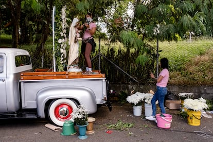 La florista Melisa Orrego decora el carro que encabeza el desfile de conductores en Medellín, durante la celebración del Día de la Virgen del Carmen.

