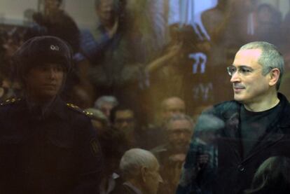 Mijaíl Jodorkovski, tras una mampara de cristal en la que se refleja el público presente en la lectura de la sentencia.