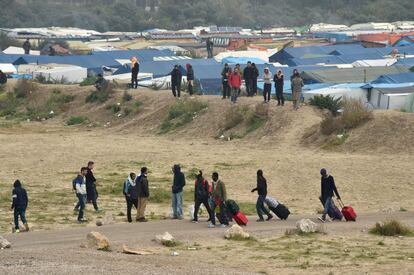 Migrantes abandonan el campo de Calais (Francia), como parte de una operación organizada por las autoridades francesas de tres días para evacuar el campamento. 