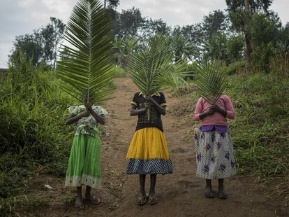 Tres muchachas esconden sus rostros a la cámara del fotógrafo en el campo de desplazados de Rho. La foto está tomada en el camino que conduce al único lugar donde pueden recoger agua potable. 