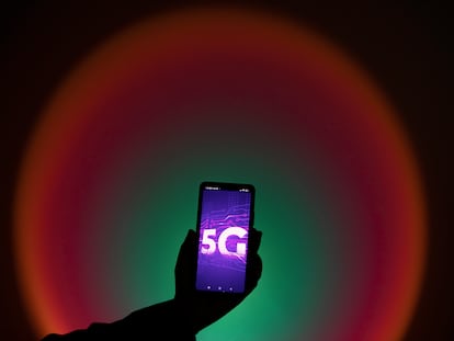 Una  persona sostiene un celular con una imagen de la tecnología 5G, en una imagen de archivo.