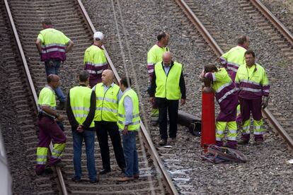 Operarios después de trabajar toda la noche en la retirada del tren siniestrado.
