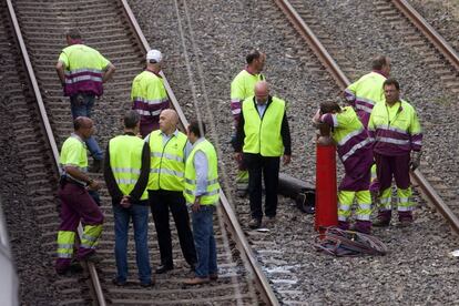 Operarios despu&eacute;s de trabajar toda la noche en la retirada del tren siniestrado.