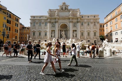 Varias personas pasean frente a la Fontana di Trevi en Roma, a finales de junio.