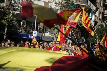 Un grup manifestants porten una gran bandera espanyola durant la manifestació.