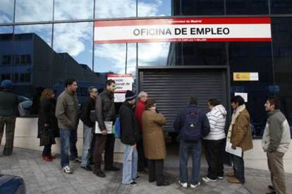Ciudadanos hacen cola ante la puerta de una oficina de empleo en Madrid.