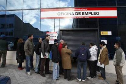 Ciudadanos hacen cola ante la puerta de una oficina de empleo en  Madrid.