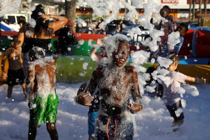 Niños israelíes juegan en una piscina de pompas de jabón en Netivot (Israel).