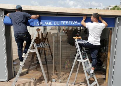 Trabajadores preparan las instalaciones de un club de playa en Cannes