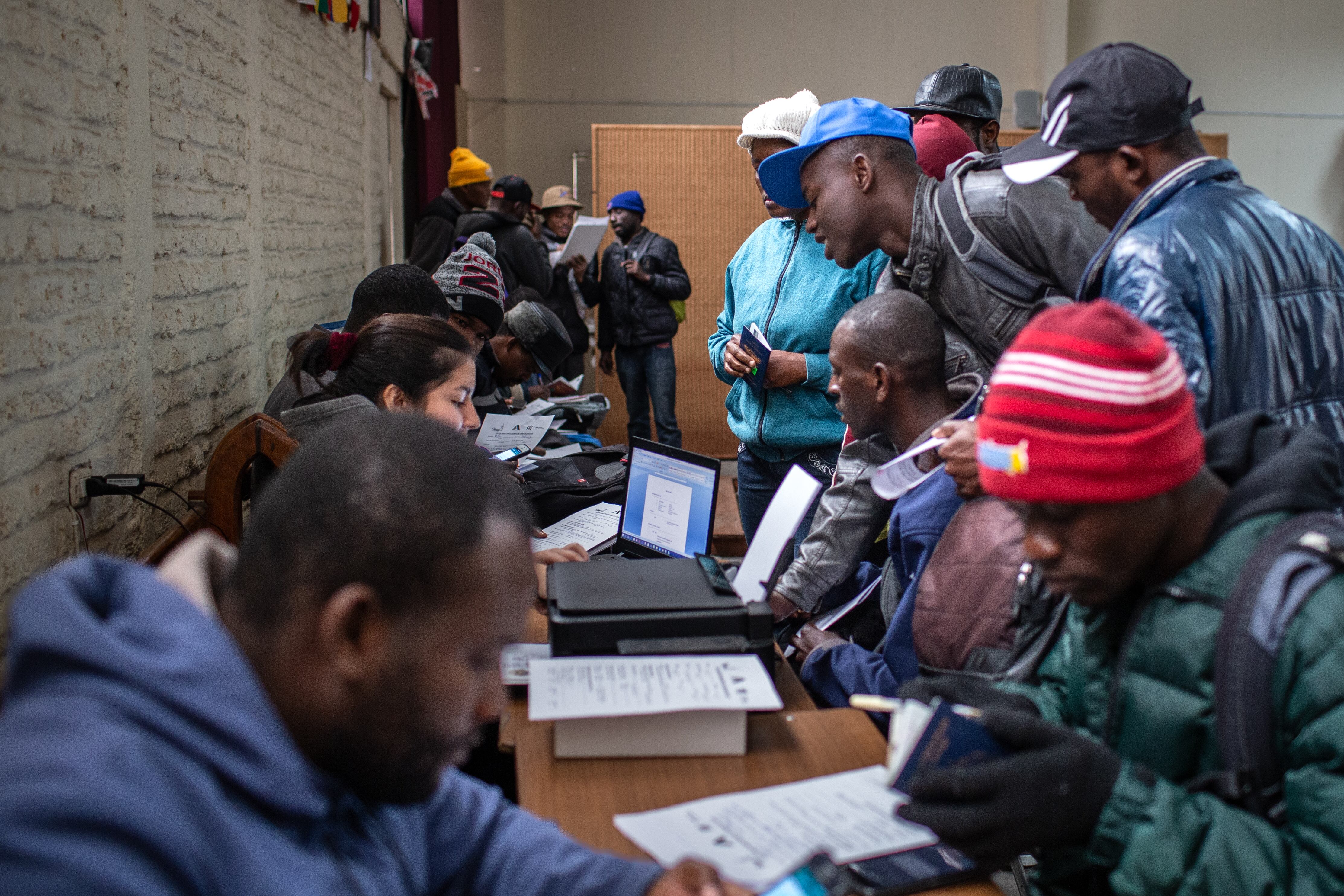 Un grupo de hombres haitianos se reúnen para recibir clases de español y de inserción cultural, en una casa de acogida para migrantes en Santiago de Chile, el 6 de mayo de 2017.