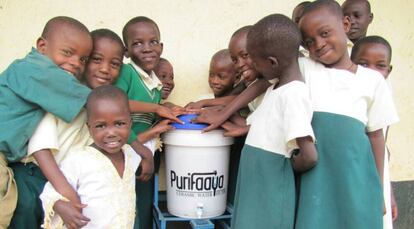 Niños ugandeses, con el dispensador de agua Purifaaya.