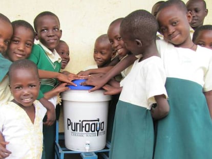 Niños ugandeses, con el dispensador de agua Purifaaya.