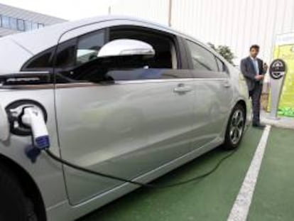 Un hombre se prepara para cargar la batería de un vehículo eléctrico. EFE/Archivo