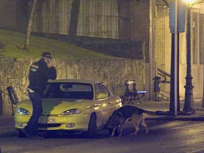 Un artificiero de la Ertzaintza inspecciona anoche un coche cerca del lugar de la explosión en el centro de Sestao, Vizcaya.