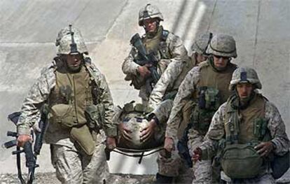 Varios <i>marines</i> trasladan a un miembro de este cuerpo herido en los combates de Faluya.
