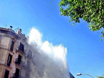 La columna de agua del reventón de la calle de Diputació superó la altura de los edificios.