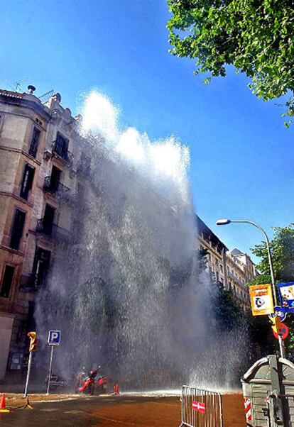 La columna de agua del reventón de la calle de Diputació superó la altura de los edificios.