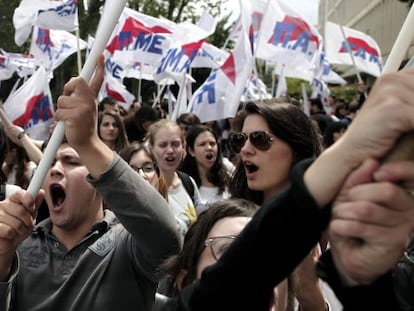 Decenas de manifestantes protestan y muestran banderas a las puertas de la sede central de la radiotelevisión pública griega, en Atenas.