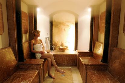 Una mujer disfruta sola de la sauna de un spa.
