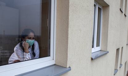 Una mujer mira a través de una ventana.