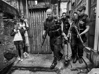 Policías de la división antiexplosivos arrestan a un hombre ante la mirada de dos niños (noviembre, 2009).
