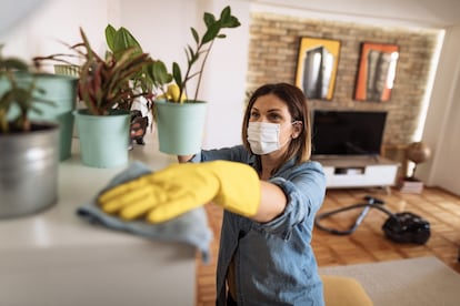 Una mujer limpiando el salón de una casa.