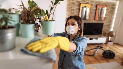 Una mujer limpiando el salón de una casa.