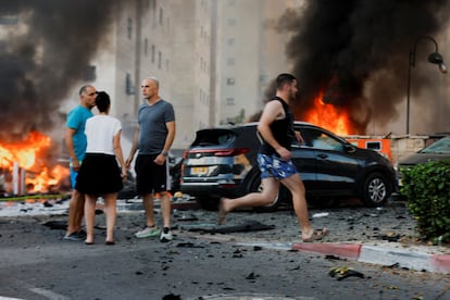 Vecinos de la ciudad israelí de Ashkelón, en la calle tras el ataque con misiles desde la franja de Gaza, el sábado. 