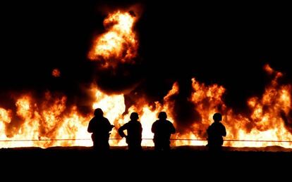 Soldados contemplan el incendio en el ducto de Pemex en Hidalgo.