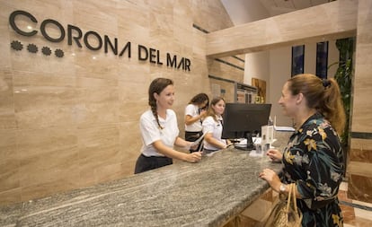 Sabina Urraca atiende a una cliente en la recepción de un hotel de Benidorm.