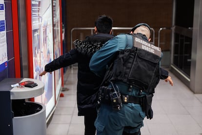 Un agente de la Guardia Civil cachea a un joven en una estación de Metro, en febrero en Madrid.