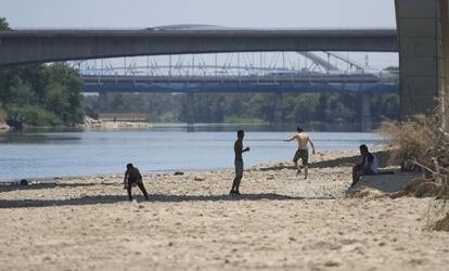 Unos jóvenes se divierten bajo de uno de los puentes que atraviesa el río Ebro.