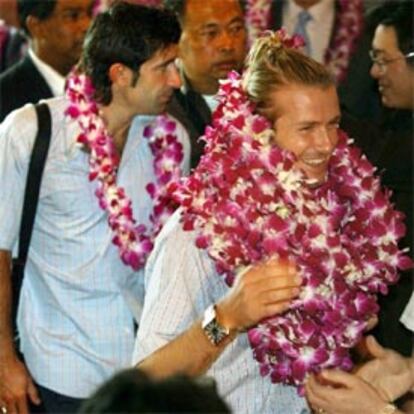 Beckham sonríe cubierto por una corona de orquídeas a su llegada al hotel Imperial Queen, en la capital tailandesa.