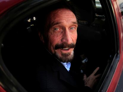 John McAfee es escoltado por funcionarios de inmigración al aeropuerto de Guatemala, diciembre de 2012.