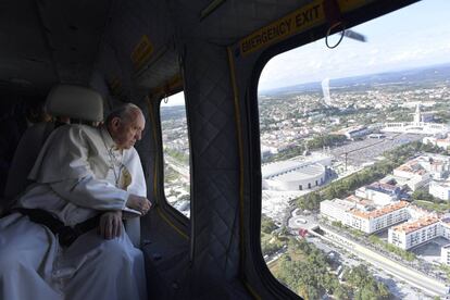 El Pontífice observa a la multitud reunida en el Santuario de Nuestra Señora de Fátima, desde la ventanilla de un helicóptero, a su llegada a Fátima.